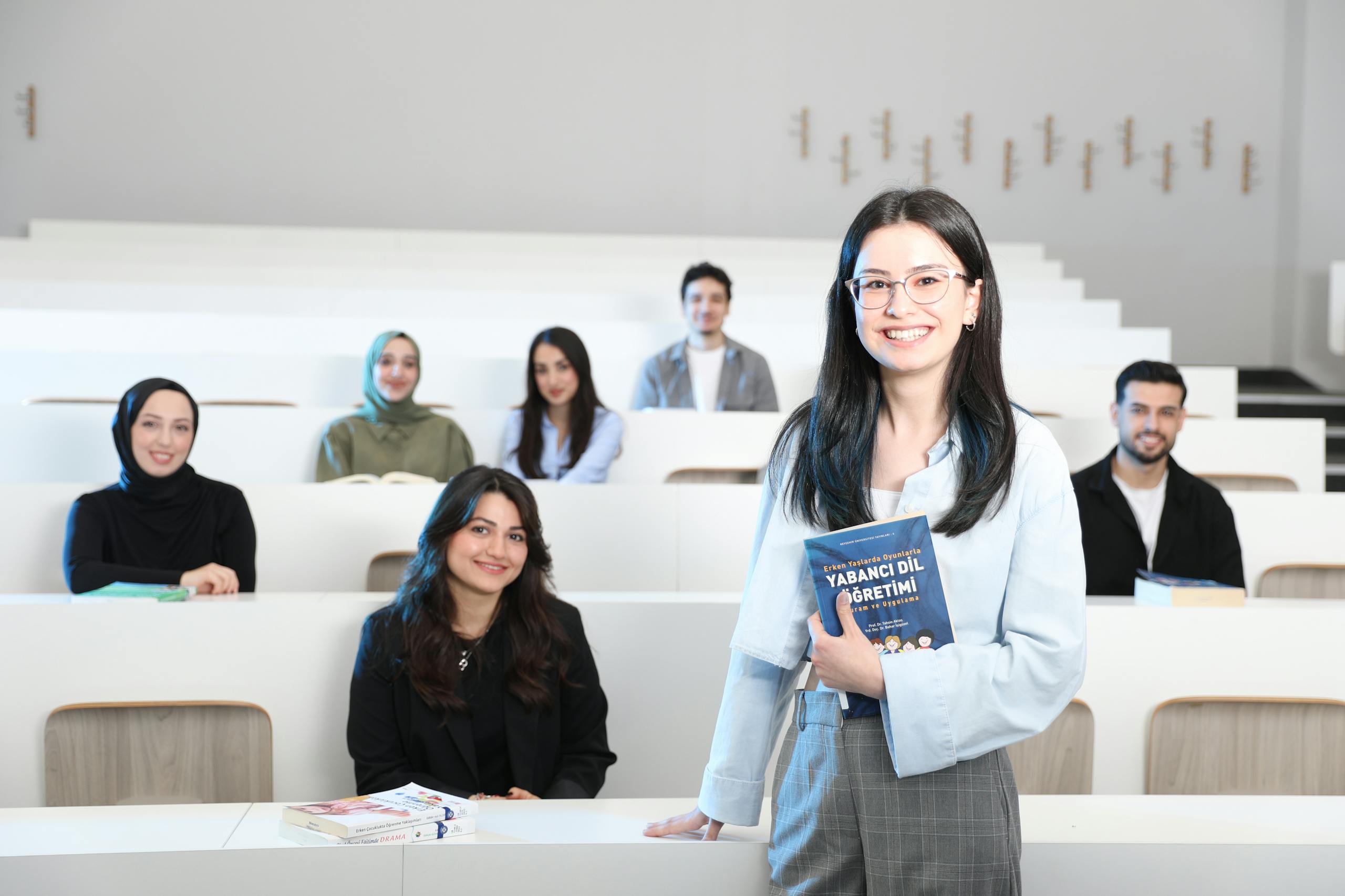 Group of diverse university students in a bright lecture hall, studying language education.
