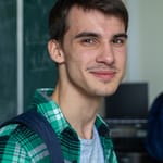 Portrait of a smiling young man in a classroom, conveying a positive educational environment.